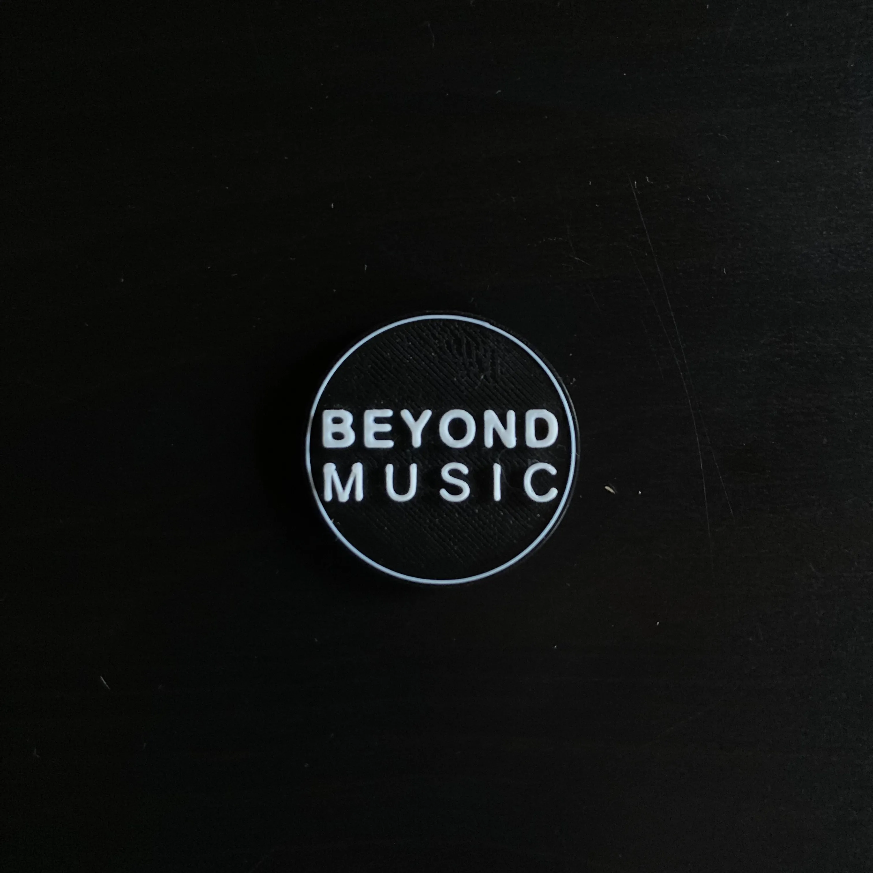 Round 3D printed Beyond Music logo fridge magnet