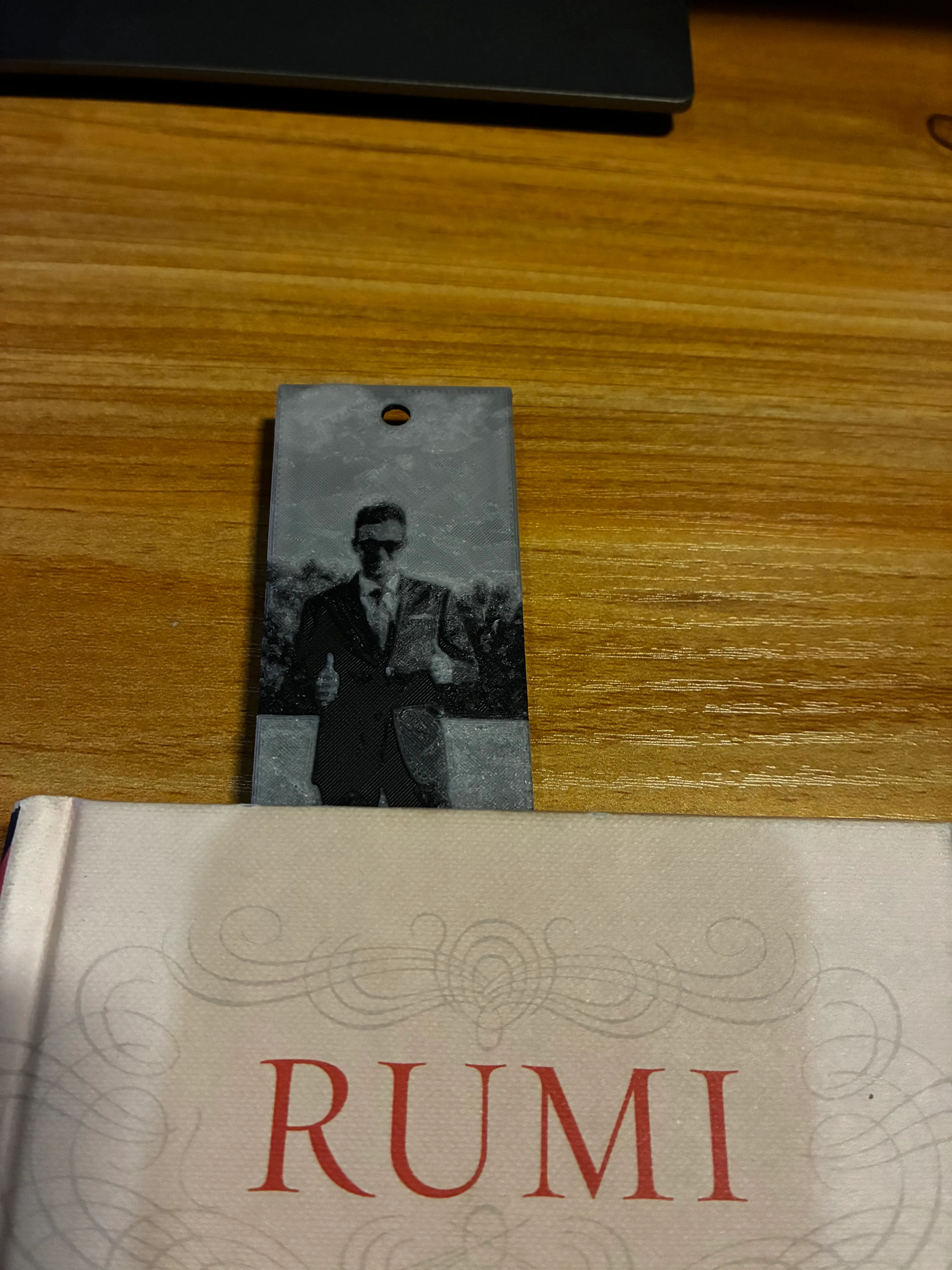 3D printed photo bookmark standing in a book of Rumi poems